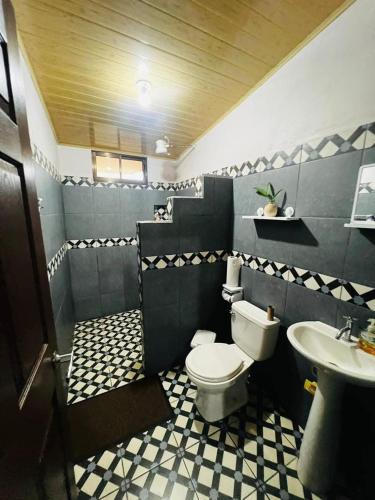 a bathroom with a toilet and a sink at Casa Eliza in Alajuela