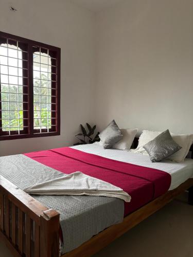 a bedroom with a large bed with a red blanket at Homestay INN in Anachal