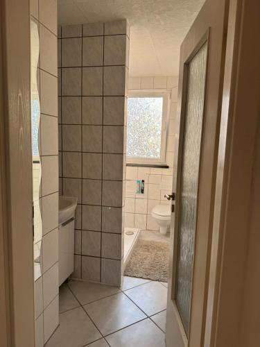 a bathroom with a tub and a toilet and a window at Silkes FeWo in Sollstedt