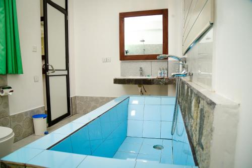 a bathroom with a blue tub and a sink at Ella Dream Mount in Ella