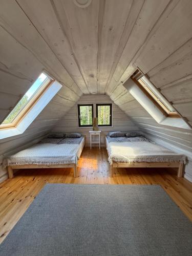 a room with two beds in a attic with windows at Tammeoja puhkemaja in Sõmeru