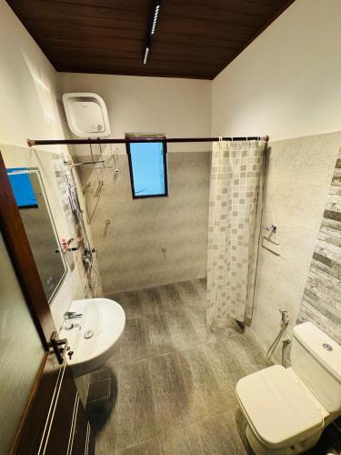 a bathroom with a sink and a toilet and a shower at US Apartment in Nochchiyagama