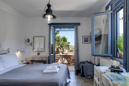 ein Schlafzimmer mit Bett und Blick auf eine Terrasse in der Unterkunft Anemousa Studios in Otziás