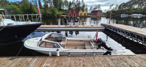 a boat is docked next to a dock at Boat Included, Waterfront Villa, Near Bergen in Lindås