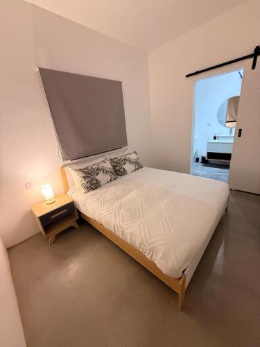 a small bedroom with a bed and a night stand at La Casa Floréal in Curepipe