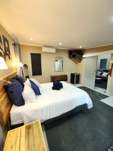 a bedroom with a large white bed and a table at Anique's Self Catering in Beaufort West