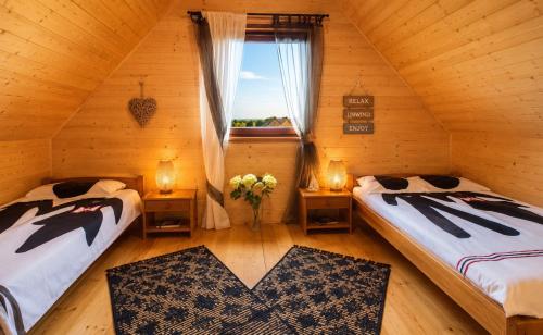 a attic room with two beds and a window at Bursztynowe Domki in Sarbinowo