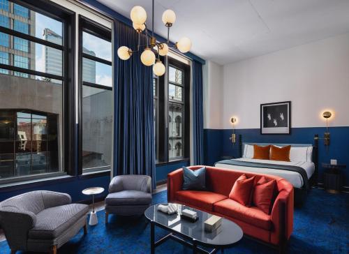a hotel room with a bed and a couch and chairs at Dream Nashville, by Hyatt in Nashville