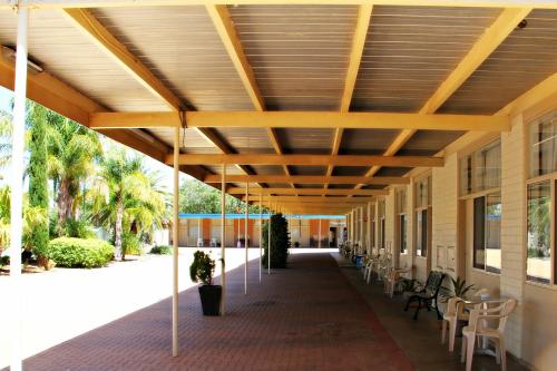 awnings on the side of a building with tables and chairs at Renmark Motor Inn in Renmark