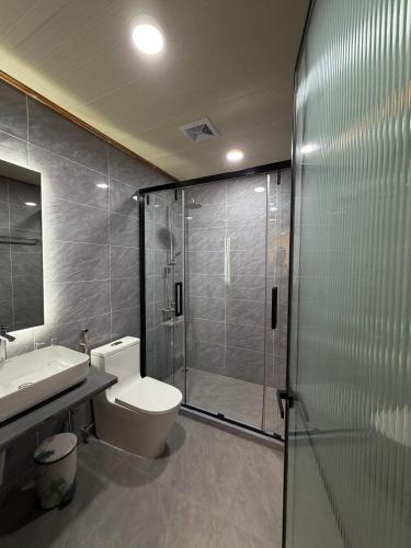 a bathroom with a shower and a toilet and a sink at Tranquil Retreat Dhigurah in Dhigurah