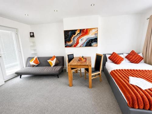 a room with a bed and a table and a couch at Jolly Jupiter at The Moon in Pontnewynydd