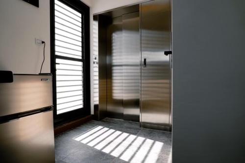 a bathroom with a walk in shower and a window at Sweet Summer Homestay in Magong