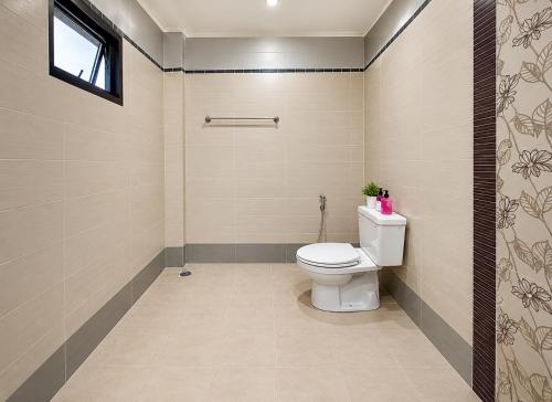a bathroom with a toilet and a window at Pool Smile Villa in Bangsaen