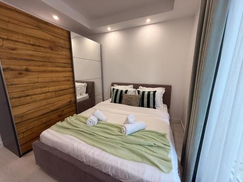 a bedroom with a bed with towels on it at Olive Apartment Cosmopolis in Tunari
