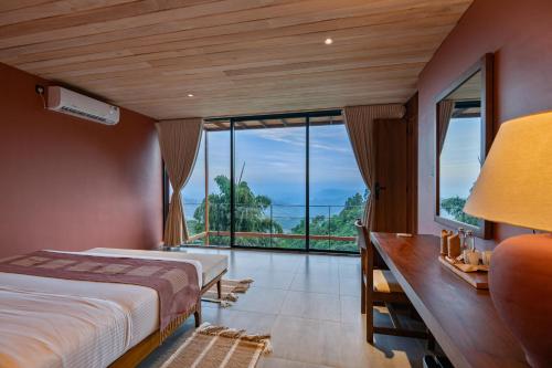 a bedroom with a bed and a large window at Villa Cavo - Beneath the Misty Peaks in Haputale