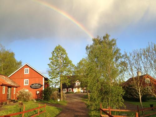 a rainbow over a farm with a red barn at Thorstorps Gård B&B in Söderköping