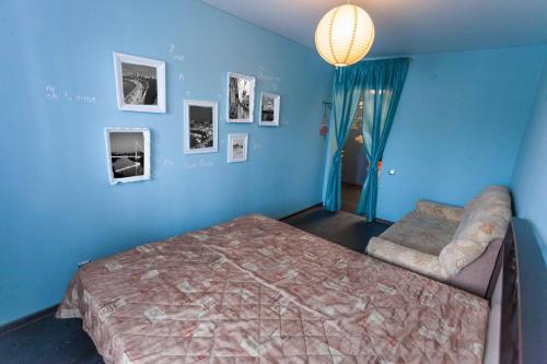 een blauwe slaapkamer met een bed en een stoel bij 3к Apartment CENTER Oktyabrya 70 in Tjoemen
