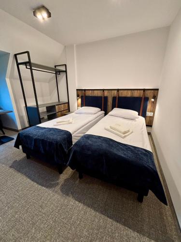 two beds in a hotel room withthritisthritislictslictslicts at Hotel&Restauracja Zamek Bytów in Bytów