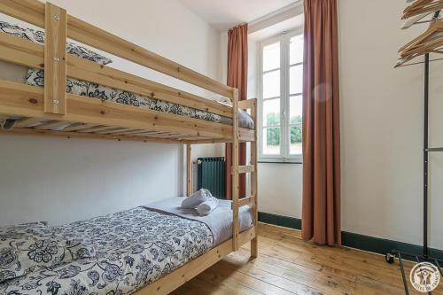 a bedroom with two bunk beds and a window at L'ecole à l'ancienne in Aulon