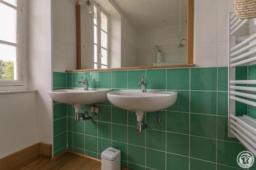 a bathroom with two sinks and a mirror at L'ecole à l'ancienne in Aulon
