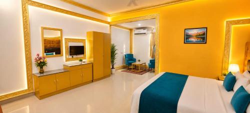 a hotel room with a bed and yellow walls at Waves P'opin Resort in Mahabalipuram