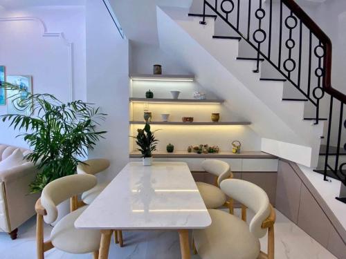 a dining room with a white table and chairs at Sunrak House in Ðạo Thành