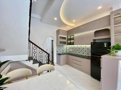 a kitchen with white walls and a black refrigerator at Sunrak House in Ðạo Thành