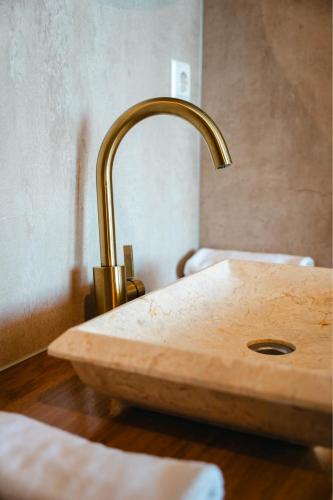 a bathroom sink with a copper faucet at Hotel Biesbosch in Drimmelen