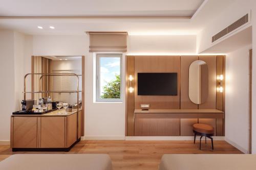 a living room with a kitchen with a tv at AKKA Hotels Antedon - Premium All Inclusive in Beldibi