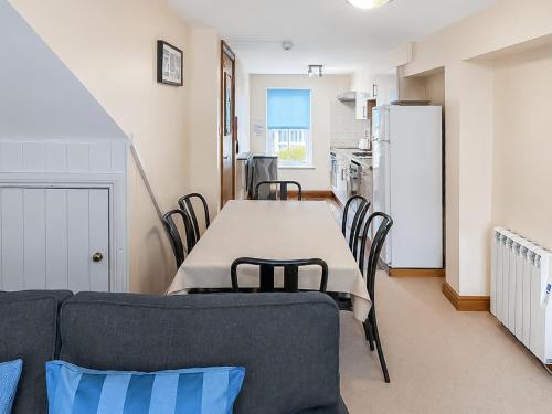 a dining room with a table and chairs and a refrigerator at Howgills Apartment 9 - Ukc9724 in Sedbergh