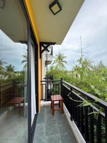 a balcony of a house with a table and a bench at Calm House 4 Hoi An in Hoi An