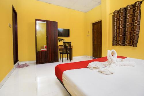 two beds in a room with yellow walls and a table at Pondy VMB Residency Starlight Hotels in Pondicherry