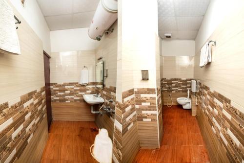 a bathroom with two sinks and a toilet at Pondy VMB Residency Starlight Hotels in Pondicherry