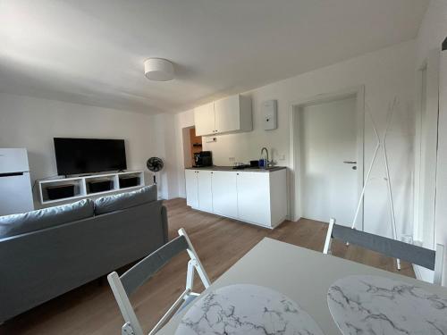 a living room with a couch and a kitchen at FeWo - An Fluss und Weinberg in Briedel