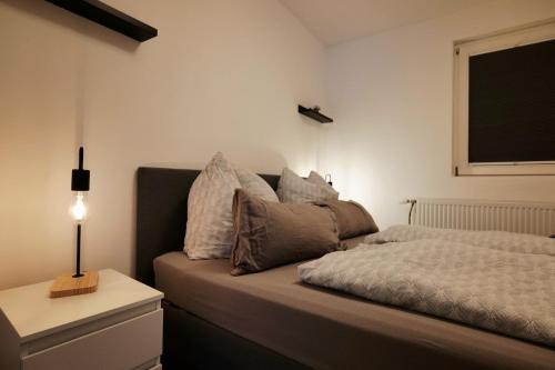 a bedroom with a bed with a night stand and a window at FeWo - An Fluss und Weinberg in Briedel