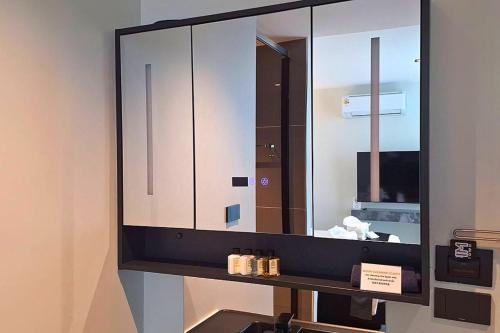 a mirror on a wall in a bathroom at Pim Old Town in Chiang Mai