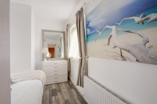 a bedroom with a painting of birds on the wall at Lorna's Apartment Self Catering Holiday Home in Milltown Malbay