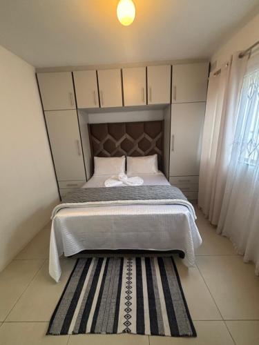 a bedroom with a bed with a headboard and a rug at Crescent Bud in Durban