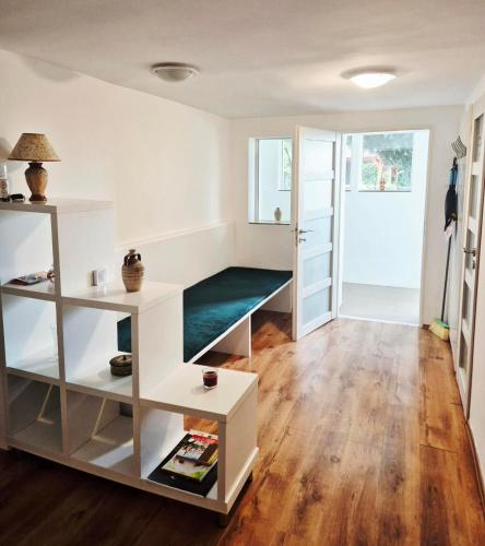 a living room with white shelves and wood floors at Riverside Forest Prestige in Chlʼaba