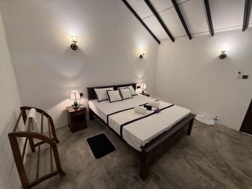 a bedroom with a large bed with two lamps on it at Wihara Cottage Sigiriya in Sigiriya