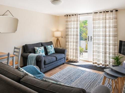 a living room with a couch and a sliding glass door at Howgills Apartment 8 - Ukc9727 in Sedbergh