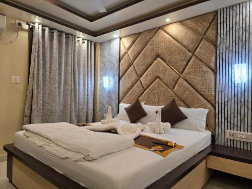 a bedroom with a large bed with white sheets at HOTEL BINAPANI Deluxe 1 in Tarapith