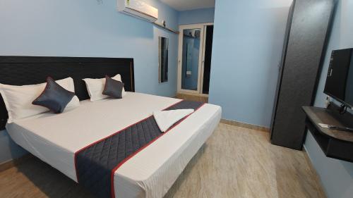 a bedroom with a large bed and a television at Vandalur Stay's Inn in Vandalūr