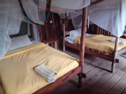 two bunk beds in a room withthritisthritisthritisthritisthritisthritisthritisthritisthritis at At the river campsite in Kihihi