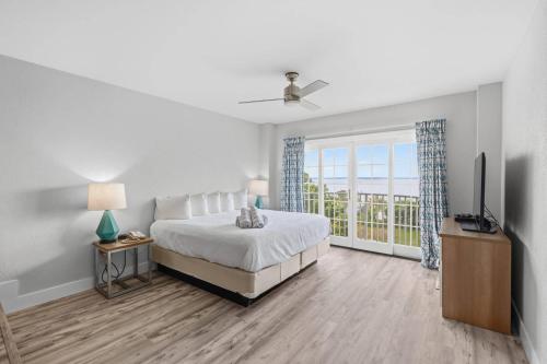 a white bedroom with a bed and a television at Coconut Malorie Resort Ocean City, an Ascend Collection Hotel in Ocean City