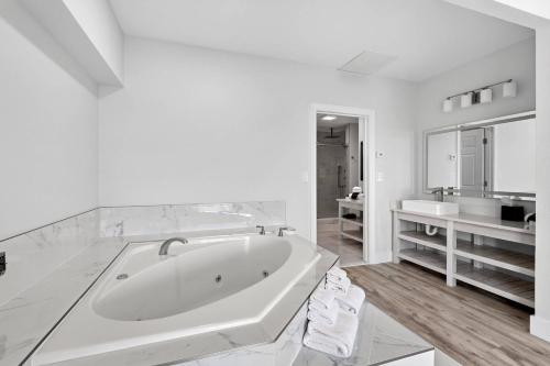 a white bathroom with a tub and a sink at Coconut Malorie Resort Ocean City, an Ascend Collection Hotel in Ocean City