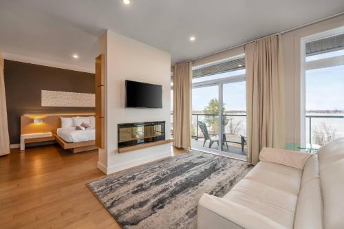 ein Wohnzimmer mit Sofa und Kamin in der Unterkunft Hôtel du Lac Champlain, an Ascend Collection Hotel in Venise-en-Québec