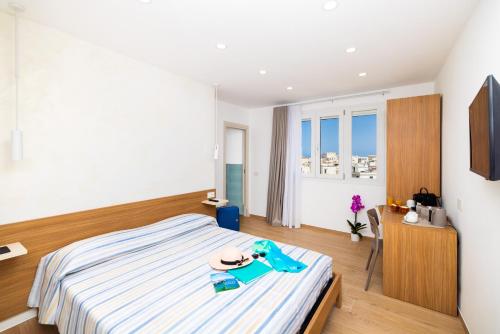 a bedroom with a bed with a hat and a table at Le 3 Viste B&B in Vieste