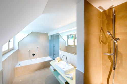 ein Badezimmer mit einem Waschbecken, einer Dusche und einer Badewanne in der Unterkunft Hotel Walkner in Seeham