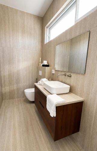 a bathroom with a sink and a toilet and a mirror at פלג טל -דפנה in Dafna